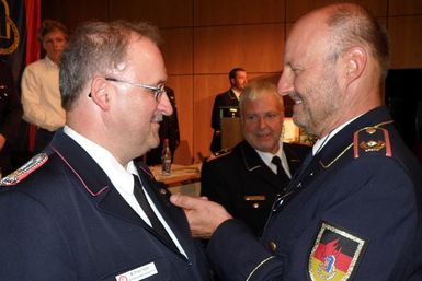 Bundesjugendleiter Hans-Peter Schäfer (r.) heftet Wilfried Vater die Ehrennadel an. In der Mitte: DFV-Präsident Hans-Peter Kröger. (Foto: Sönke Jacobs/DFV)