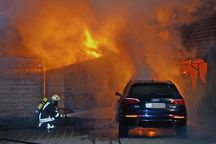 An der Heinrich-Böll-Straße schlug das Feuer vom Pkw auf das angrenzende Carport über. Die ersten Kräfte nehmen den Schnellangriff vor.